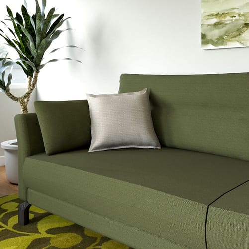 cream pillow with olive green sofa